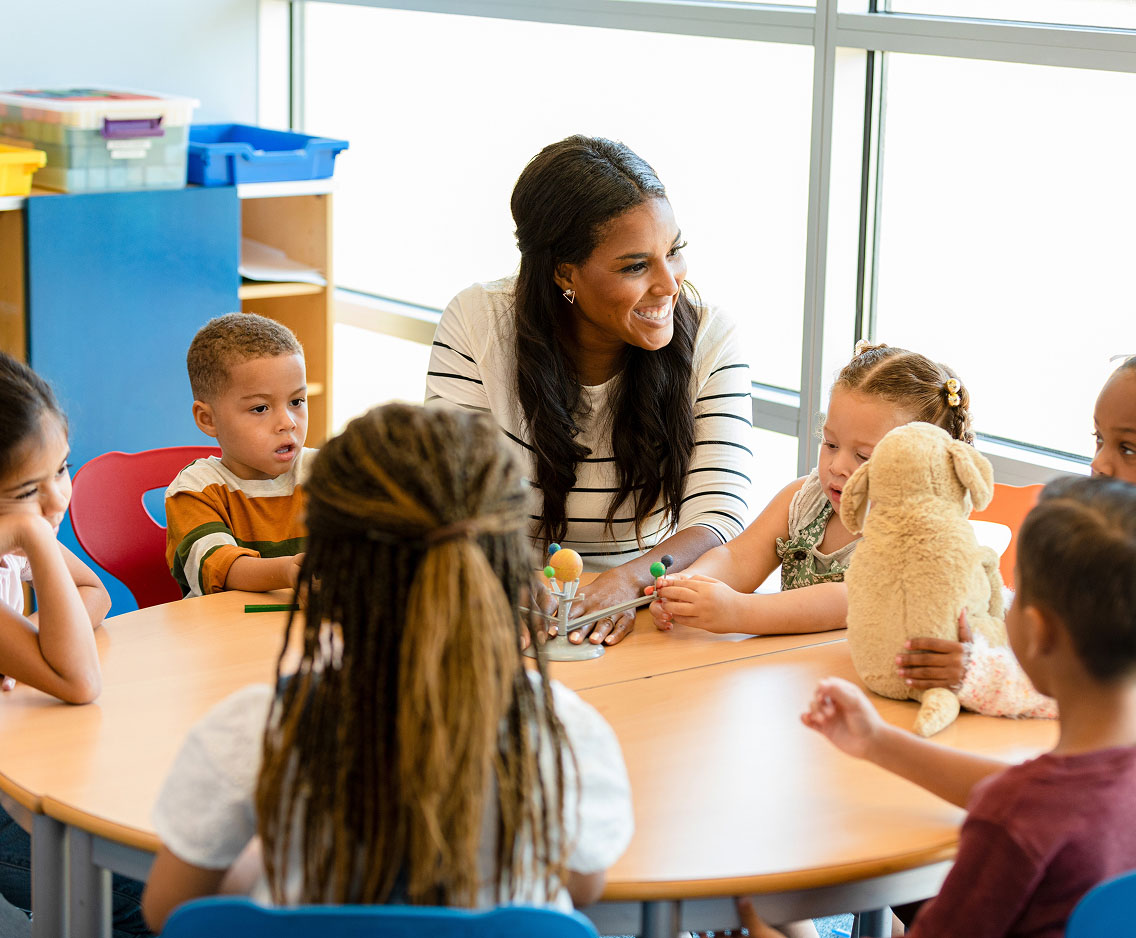 A young teacher with a class of kindergartners