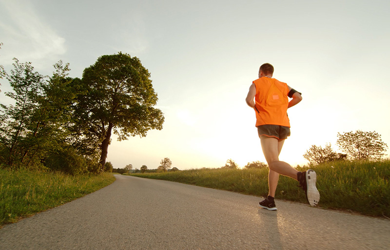 A man runs on a blacktop path.
